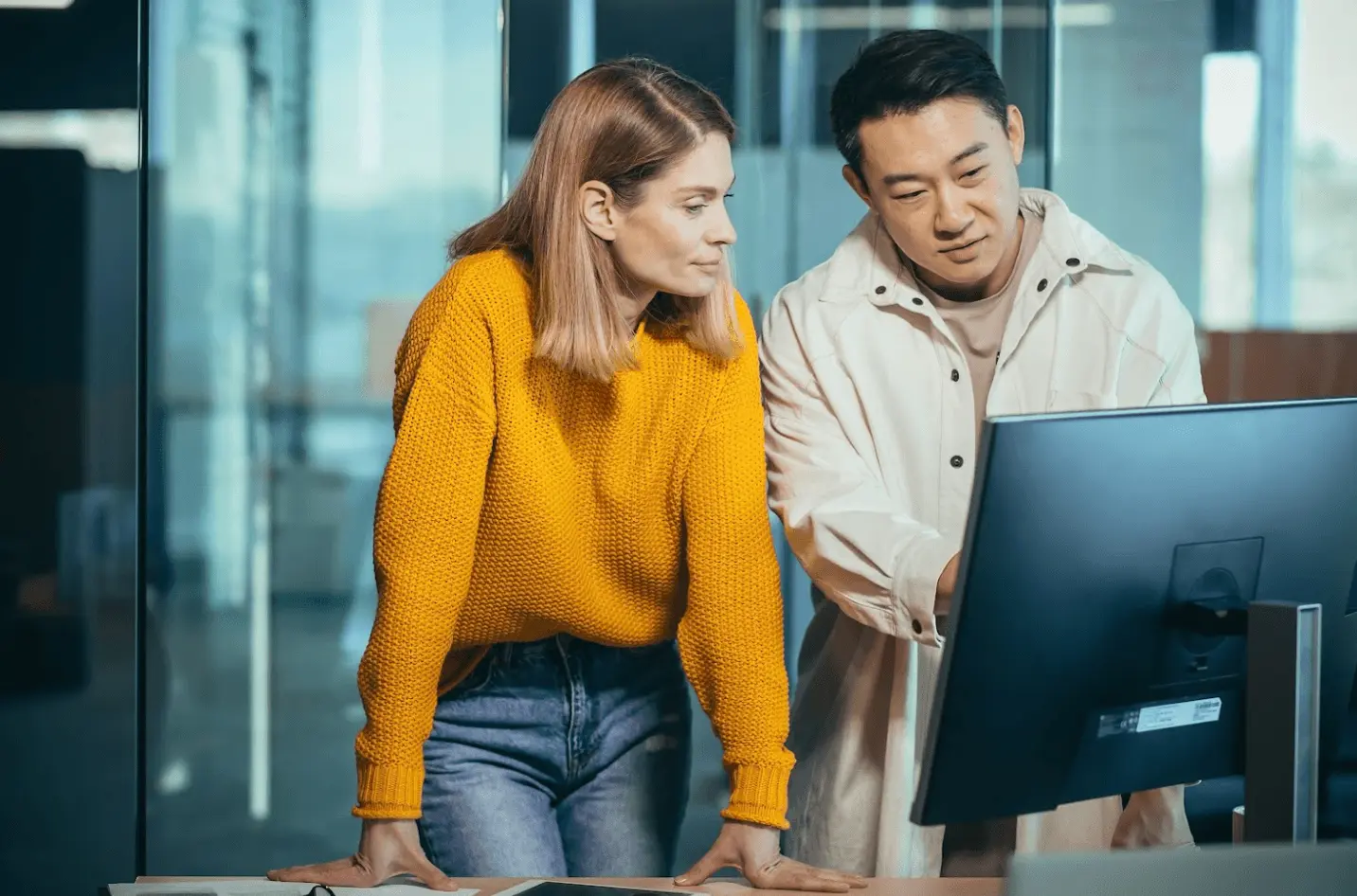 Two professionals reviewing work on a laptop